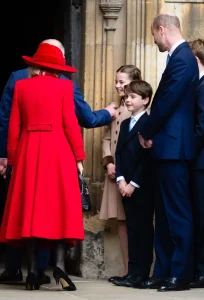 King Charles walking hand in hand with Princess Charlotte after Easter service, smiling and leaning down to talk to her — a rare candid royal moment