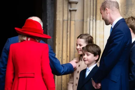 King Charles walking hand in hand with Princess Charlotte after Easter service, smiling and leaning down to talk to her — a rare candid royal moment